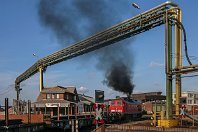 km 4,1  Wiederum nur ein paar Meter weiter überquert die Bahn die Berzeliusstraße. Der Bahnübergang machte hier in der Vergangenheit regelmäßig Probleme, und so hat diese 232 ihn erst einmal im Schritttempo überfahren, bevor sie nun aufdreht. Im Gegensatz zum vorangegangenen Bild würde man diese Szene heute kaum wiedererkennen. Die Leitungsbrücke und das Verwaltungsgebäude links existieren nicht mehr, und auch der Bahnübergang wurde modernisiert (15. Februar 2007). : 2, 232 (DR 132), Str 2315 DU-Hochfeld Süd - HKM, a - Aufnahmeort, a Deutschland, ao Duisburg, ao Duisburg-Wanheim, eb DB 232 xxx, es 2315 km 4-1