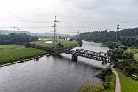 km 43,8  Zwischen dem Abzweig Essen-Überruhr bei Kilometer 37,8 und Bochum-Dahlhausen (Kilometer 44,1) ein gänzlich anderes Bild: Hier ist die Strecke seit 1959 für den Personenverkehr stillgelegt, dem später auch der Güterverkehr und der Gleisabbau folgte. An diesen kurzen Abschnitt der Strecke erinnern nur noch wenige Relikte, darunter diese Fachwerk-Ruhrbrücke mit Vorfluter aus dem Jahr 1927. Hinter der Brücke ist eine zweite für Rad- und Fußwanderer zu erkennen, die 1988 auf dem Widerlager des zweiten Gleises aufgebaut wurde (4. September 2021).