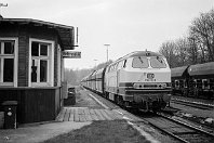 km 9,3  Das waren noch Zeiten, als Hofermühle wirklich noch einen besetzten Bahnhof hatte, an dem Zugkreuzungen stattfanden! 216 112-3 erreicht mit einem Ganzzug das kleine Stellwerk des Bahnhofs, im Hintergrund steht ein weiterer Güterzug abgestellt. Heute liegt hier nur noch das durchgehende Streckengleis, und der Angertalbahn fehlt ein wichtiger Unterwegsbahnhof. Dabei hat der Bahnhof Hofermühle über Jahrzehnte die Zugkapazität der Strecke beachtlich erhöht (10. April 1990). : 2, 216 (DB V 160), Str 2404 Ratingen - Wülfrath, a - Aufnahmeort, a Deutschland, ao Heiligenhaus-Hofermühle Bf, eb DB 216 112-3, ef 31218 Henschel (1967), es 2404 km 9-3