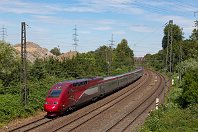 km 91,4  Von der alten Bahnbrücke, die auf dem vorangegangenen Foto zu sehen war, entstand diese Aufnahme am 22. Juli 2019: Der Thalys 4342 rauscht auf Gelsenkirchen zu. Ganz vorne ist wieder das Gleis der Strecke 2239 zu sehen, das auch vom Nahverkehr benutzt wird. Links im Hintergrund sind die Schuttberge der Baureifmachung des Gewerbegebiets »Schalker Verein« zu sehen. Und die rote Brücke im Hintergrund gehört zur »Erzbahntrasse«, einer wichtigen Radwegeverbindung. : 2, Str 2650 K-Deutz - Hamm, Thalys, a - Aufnahmeort, a Deutschland, ao Gelsenkirchen, ao Gelsenkirchen-Bulmke-Hüllen, eb Thalys 4342, es 2650 km 91-4