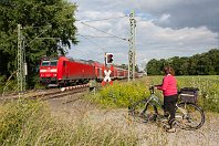 km 112,4  Bei Bremen-Mahndorf durchfährt die Bahn die Felder der Osterholzer Feldmark. Der Bahnübergang wird gerne von Spaziergängern und Radfahrern genutzt, um einen größeren Umweg abzukürzen. Die Radfahrerin wartete hier geduldig ab, bis 146 104 mit ihrem Regionalexpress Hannover – Norddeich außer Sichtweite ist (14. Juni 2014). : 146, 91 80 6146, Str 1740 Wunstorf - HB - BHV, a - Aufnahmeort, a Deutschland, ao Bremen, ao Bremen-Mahndorf, eb DB 146 104-5, ef 33948 Bomb Ksl, en 91 80 6146 104-5, es 1740 km 112-6