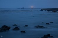 Piedras Blancas Light (California, USA)  Entlang des Pacific Coast Highways befinden sich zahlreiche sehr schöne Leuchttürme an der traumhaften Küste. Nicht dazu gehört der 1879 gebaute Leuchtturm Piedras Blancas, der schon 1949 nach einem schweren Sturm seine Laterne verlor. Seitdem kreist nur ein Scheinwerfer auf dem Turmstumpf. Zurzeit bemüht sich eine Organisation um eine Rekonstruktion der Laterne, um diesen Leuchtturm in seinem ursprünglichen Aussehen zu erhalten. Davon war bei unserem Besuch im Juni 2009 noch nicht viel zu erkennen, als wir von San Simeon aus über die abendliche Küste hinweg den Lichtschein des Turms fotografierten (23. Juni 2009). : A San Simeon, Aufnahmeort, LT Piedras Blancas, Leuchttürme, USA