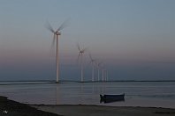 Windpark von Thyborön  Die gigantischen Windkraftanlagen sind mittlerweile nicht mehr aus den europäischen Landschaften fortzudenken. Wie am Lineal gezogen steht diese Anlage aus sieben Rotoren am Limfjord südlich von Thyborøn und erzeugt Strom. Über einen aufgeschütteten Weg, der nur knapp aus dem Wasserspiegel ragt, kann man die »Spargelstangen« ablaufen (22. Mai 2018).